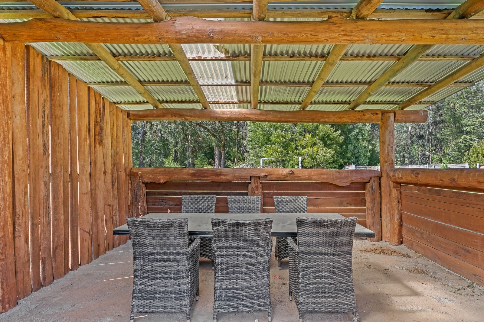 An outdoor dining setting under a timber pergola