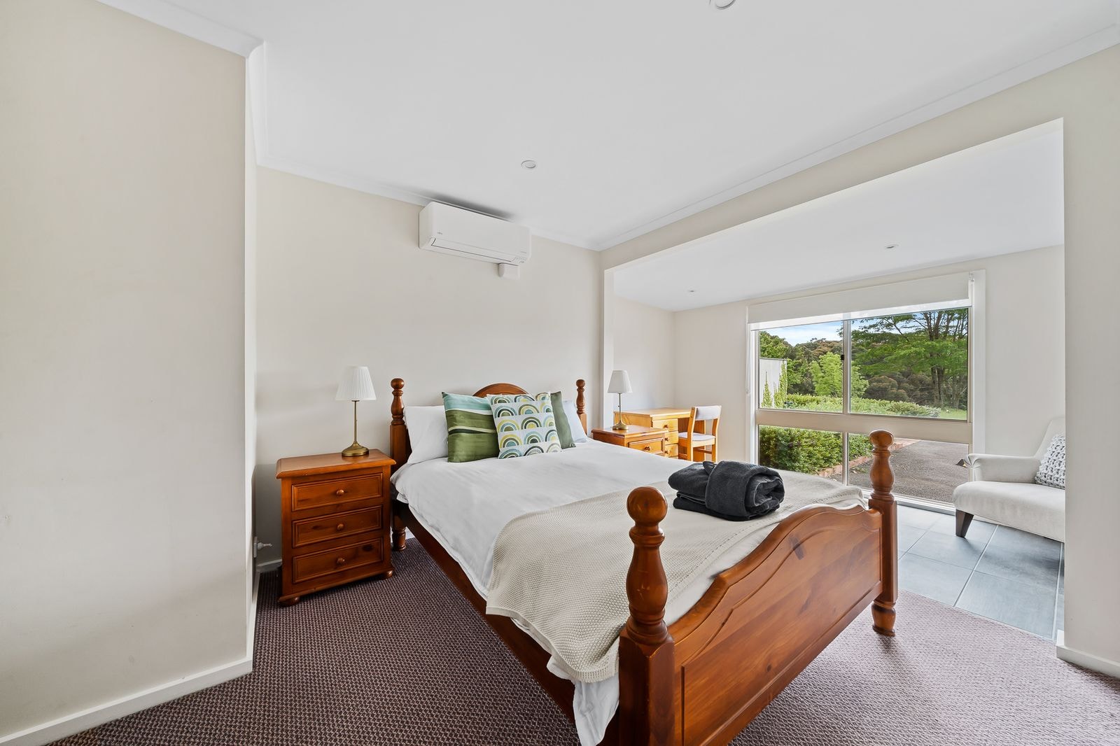 A queen guest room with timber bedhead